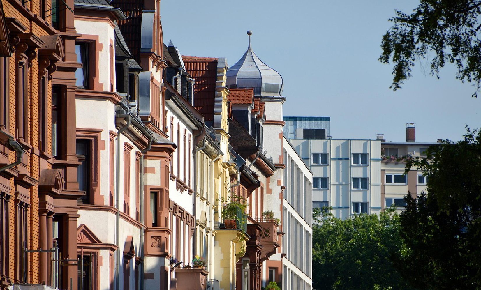 Straße mit einer Mischung aus Altbau- und Neubauimmobilien