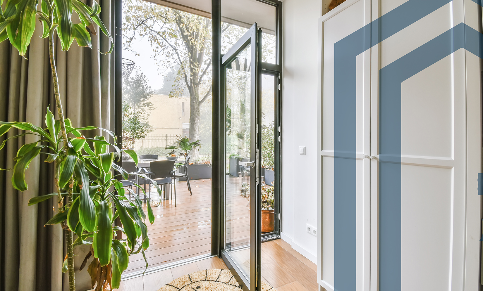 Moderner Balkon mit offener Glastür und Blick ins Wohnzimmer
